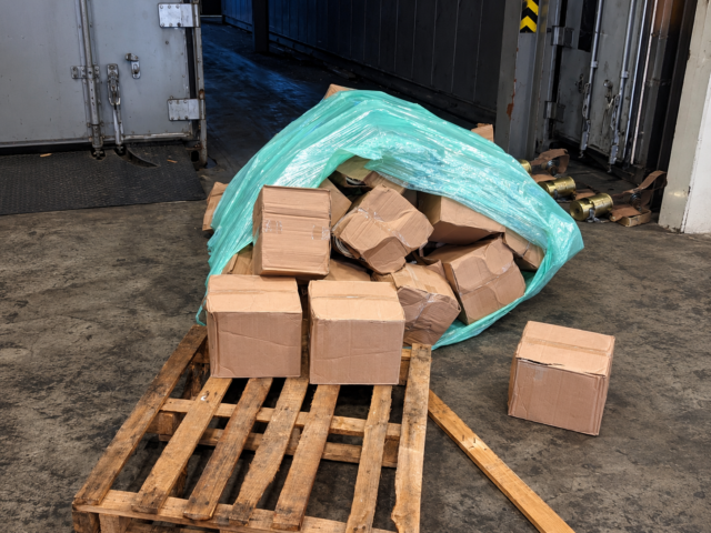 Dramatic warehouse interior at night with stacked pallets illuminated by forklift work lights, representing cargo safety in South African logistics