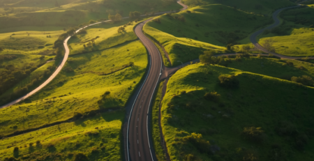 Aerial view of a lush South African highway winding through green KwaZulu-Natal hills at golden hour, representing sustainable logistics